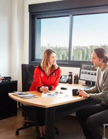 saleswoman speaking with a client in her office